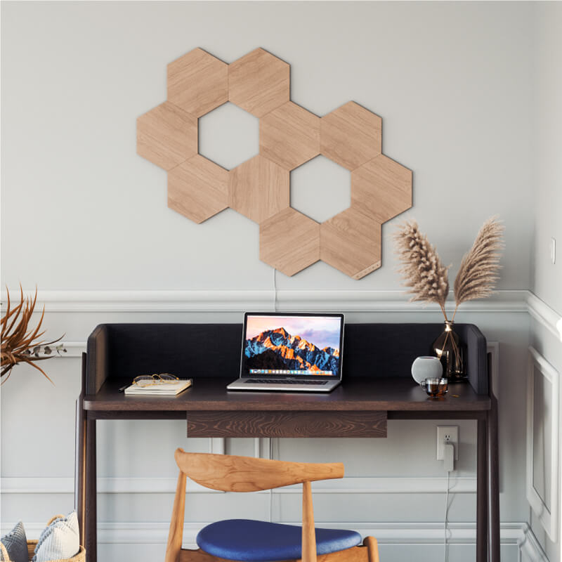 Painéis de luz inteligente Nanoleaf Elements modulares hexagonais com aparência de madeira, ativados por Thread,, montados na parede de um home office. HomeKit, Google Assistant, Amazon Alexa, IFTTT.