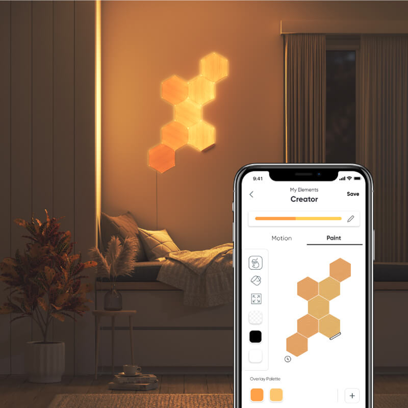 Nanoleaf Elements Thread enabled wood look hexagon smart modular light panels mounted to a wall above a cozy nook. Nanoleaf App. HomeKit, Google Assistant, Amazon Alexa, IFTTT.