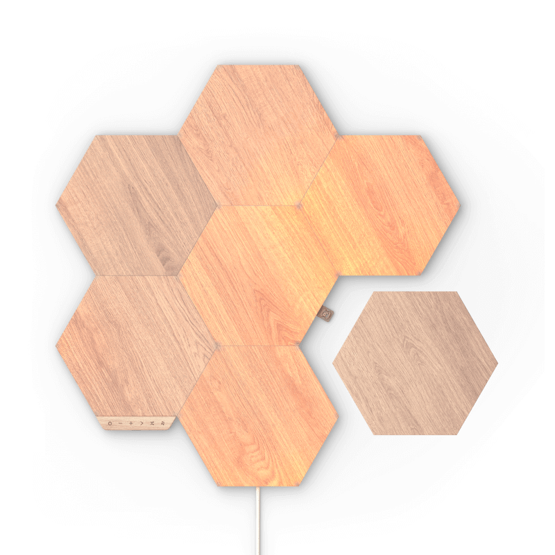 Painéis de luz inteligente Nanoleaf Elements modulares hexagonais com aparência de madeira, ativados por Thread. Pacote com 7. Possui pacotes de expansão e acessórios de conector flexível. HomeKit, Google Assistant, Amazon Alexa, IFTTT. 