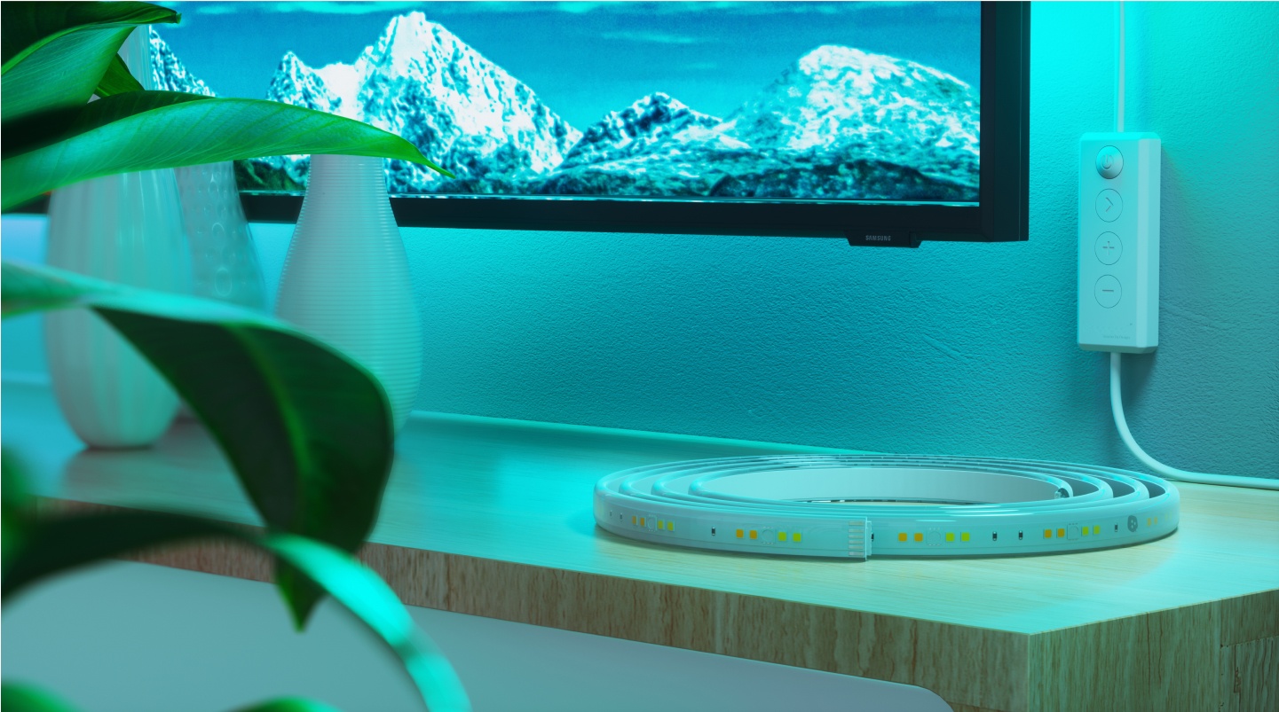 Configuração do quarto do escritório com luzes RGB Nanoleaf Lines montadas acima da mesa e do monitor. As luzes de jogo perfeitas para a sua estação de jogos do PC.