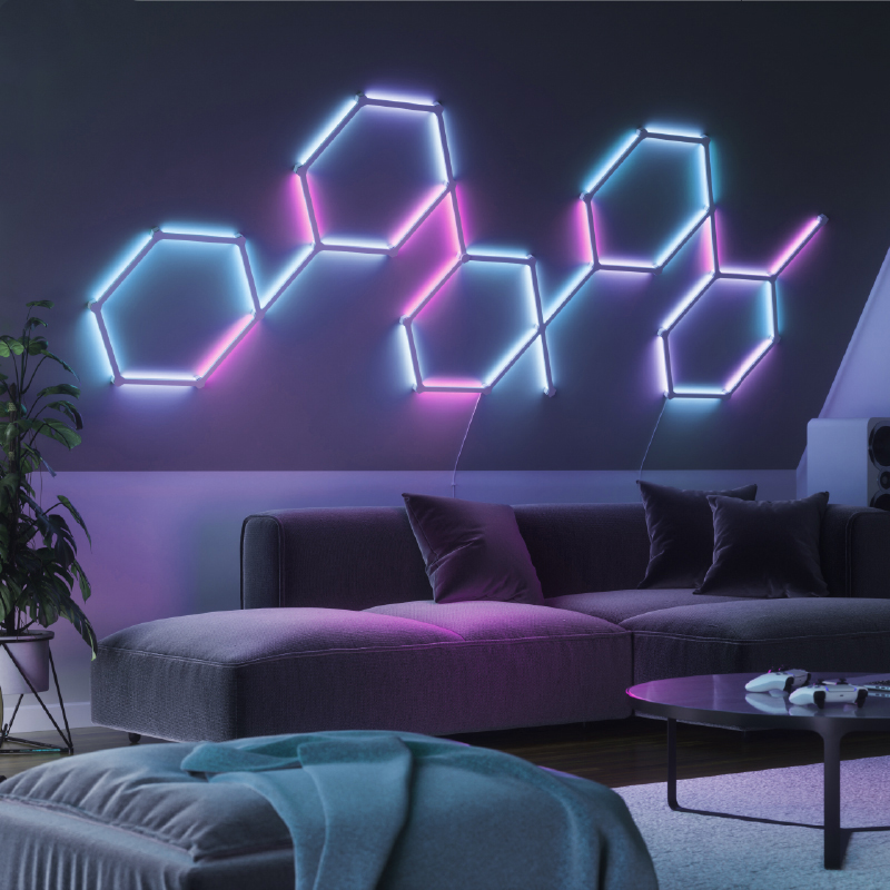 Linhas de luz de fundo inteligente Nanoleaf Lines modulares com mudança de cor e ativadas por Thread, montadas na parede de uma sala de estar. HomeKit, Google Assistant, Amazon Alexa, IFTTT.