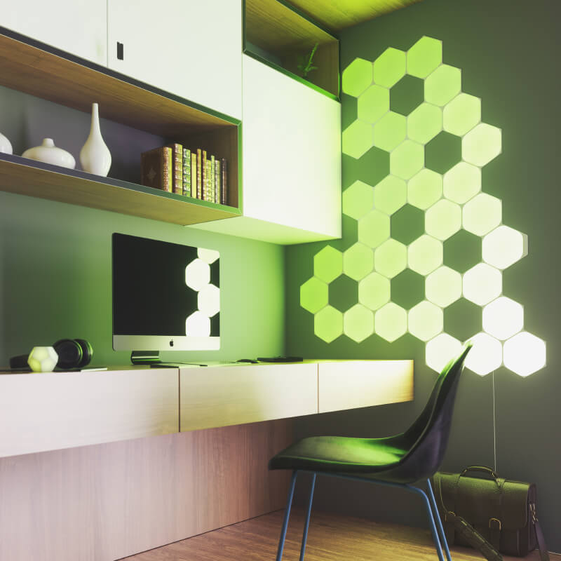Painéis de luz inteligente Nanoleaf Shapes modulares hexagonais com mudança de cor e ativados por Thread, montados na parede de um home office. Semelhante ao Philips Hue, Lifx. HomeKit, Google Assistant, Amazon Alexa, IFTTT.