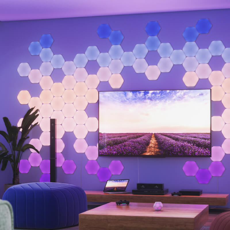 Painéis de luz inteligente Nanoleaf Shapes modulares hexagonais com mudança de cor e ativados por Thread, montados na parede de uma sala de estar. Semelhante ao Philips Hue, Lifx. HomeKit, Google Assistant, Amazon Alexa, IFTTT.