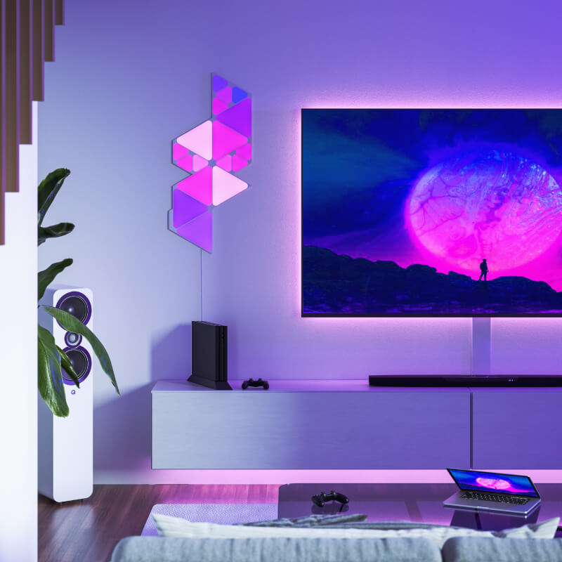 Painéis de luz inteligente Nanoleaf Shapes modulares minitriangulares com mudança de cor e ativados por Thread, montados na parede de uma sala de estar. Semelhante ao Philips Hue, Lifx. HomeKit, Google Assistant, Amazon Alexa, IFTTT.