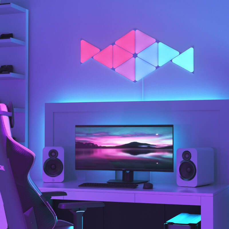 Nanoleaf Shapes Thread enabled color changing triangle smart modular light panels mounted to a wall above a battlestation. Similar to Philips Hue, Lifx. HomeKit, Google Assistant, Amazon Alexa, IFTTT.