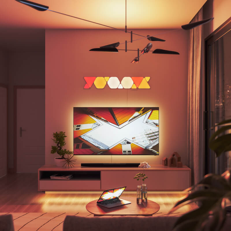 Painéis de luz inteligente Nanoleaf Shapes modulares triangulares com mudança de cor e ativados por Thread, montados na parede de uma sala de estar. Semelhante ao Philips Hue, Lifx. HomeKit, Google Assistant, Amazon Alexa, IFTTT.
